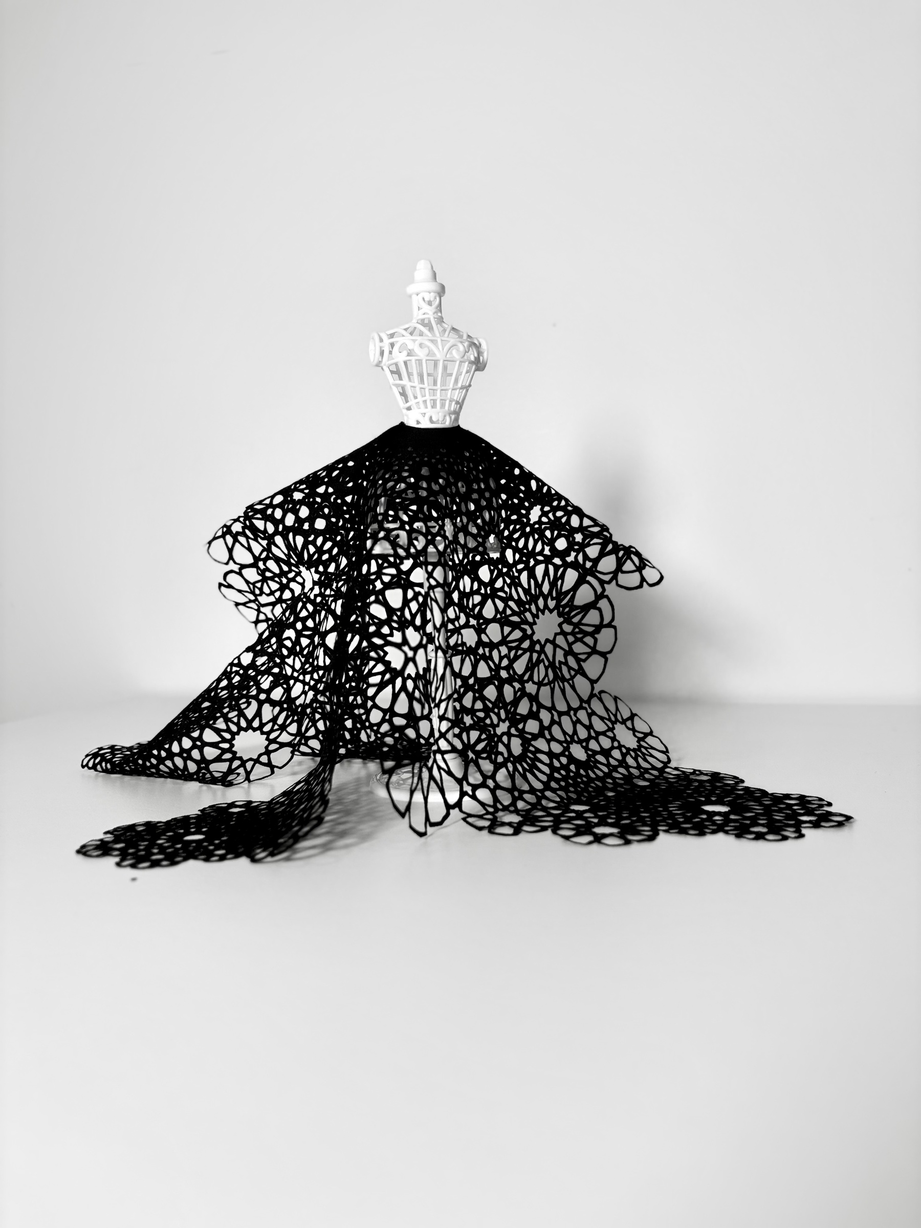 Textile Studies: a black geometric cutwork skirt draped on a miniature white dress form
