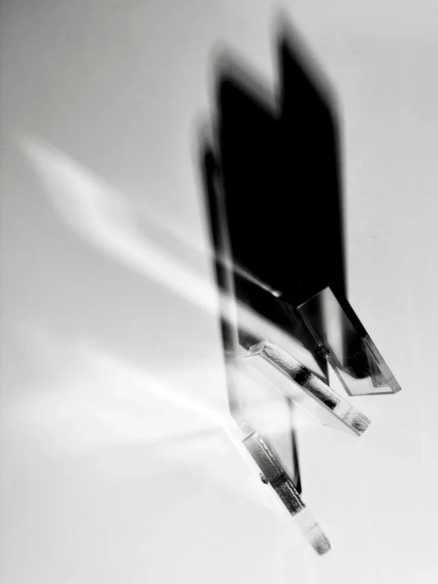 Black and white study of clear acrylic pieces casting elongated shadows