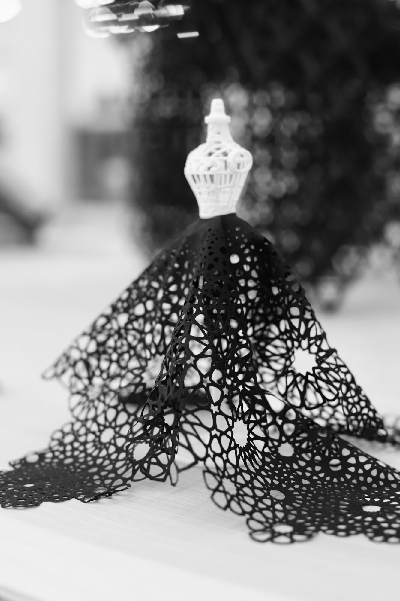 Angled detail of a black cutwork textile sculpture and its rosette pattern at Polymaths