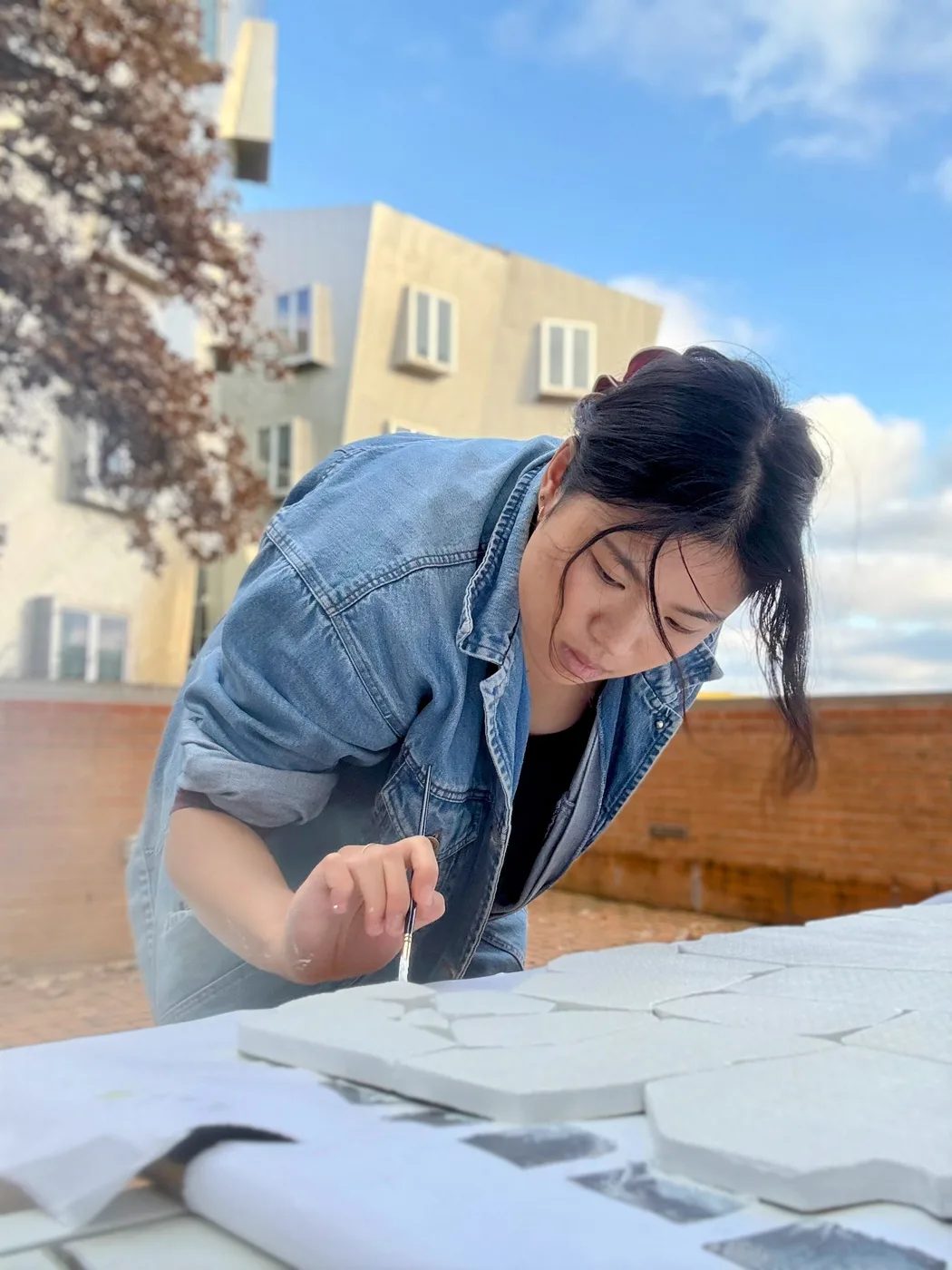 Rebecca Lin painting a geometric model outside the Stata Center